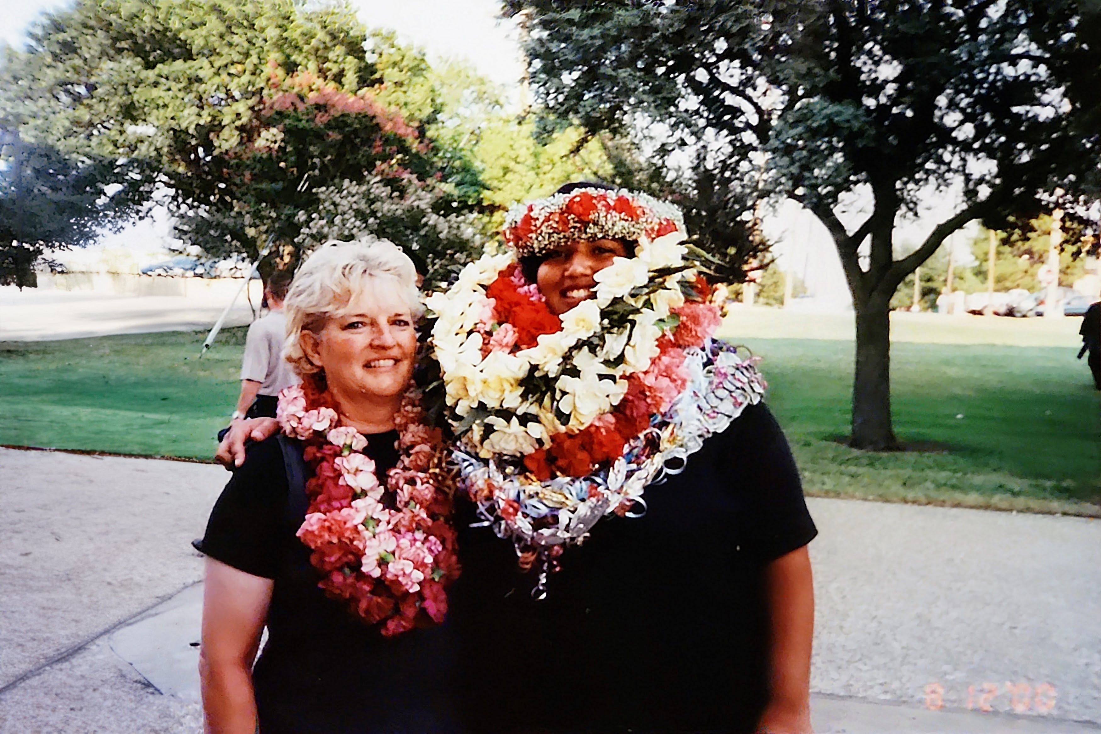 A college graduate and her mother in handmade fresh flower Hawaiian leis