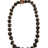 Hand-strung brown kukui nut lei with ribbon tie on a white background