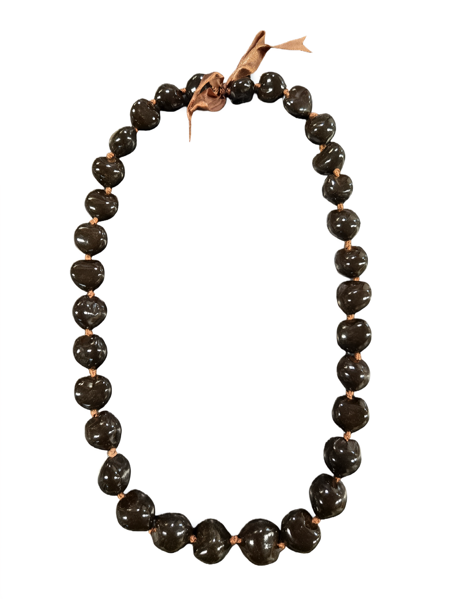 Hand-strung brown kukui nut lei with ribbon tie on a white background