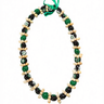 Green kukui nut lei with black beads and natural shell accents, isolated on white