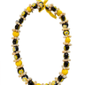 Yellow and black kukui shell lei with natural shell accents on a white background